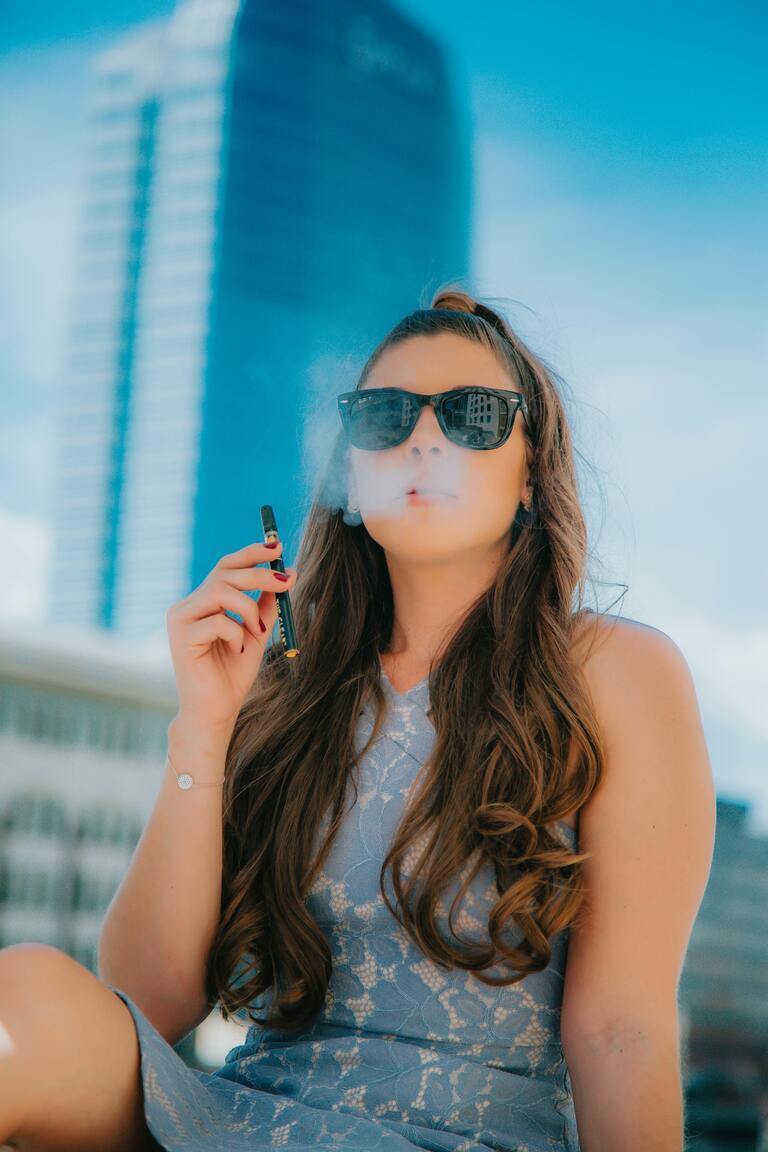 Woman puffing a CBD vape pen