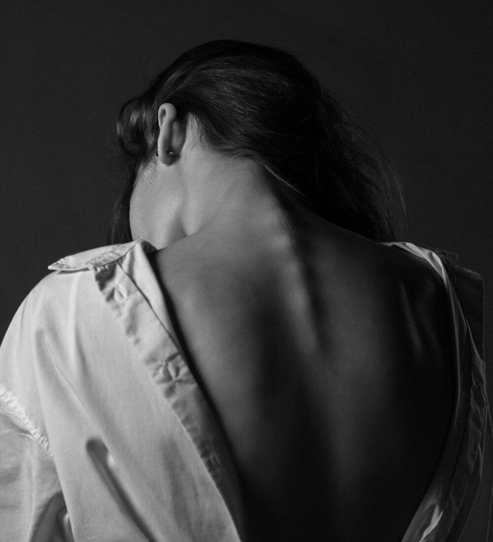 CBD For Sciatica girl wearing white shirt showing her back