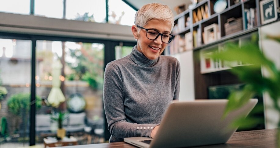 Woman sitting at a desk looking at a computer.