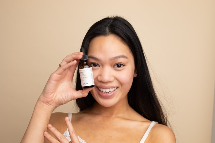 person holding a vial of cbd oil for acne